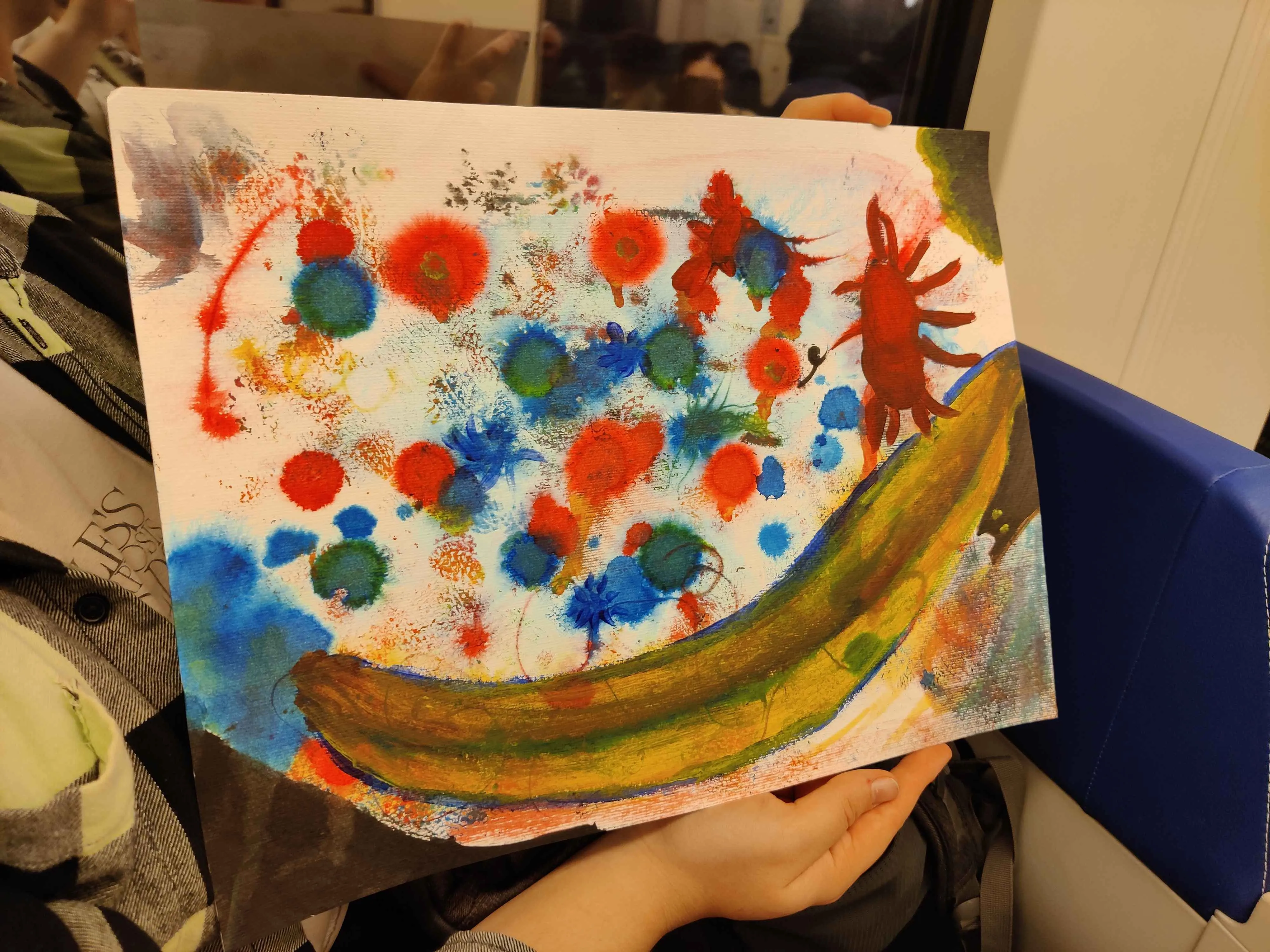 what is probably a child's unframed painting, featuring a sloppy, turdlike, far-too-long banana stretching across the side and length of the painting. two corners are rounded off in brown, one leaking into green, and there are splotches of blue and orange-red occupying the remainder of the space. one red stain features many lines radiating off from it, suggesting a crab or perhaps a long-legged, dead pillbug.